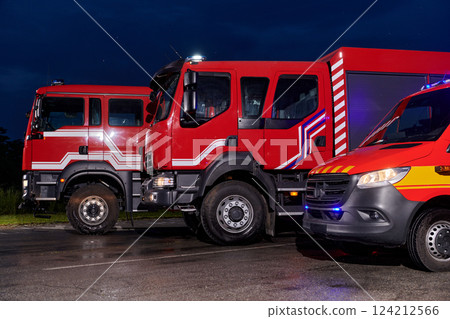 A pair of highly modern and quality fire trucks illuminate the night with their rotating lights, symbolizing the cutting-edge technology and preparedness of the firefighting fleet, ready to respond to A pair of highly modern and quality fire trucks illuminate the night with their rotating lights, symbolizing the cutting-edge technology and preparedness of the firefighting fleet, ready to respond to 124212566