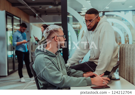 Young group of business people brainstorming together in a startup space, discussing business projects, investments, and solving challenges. 124212704