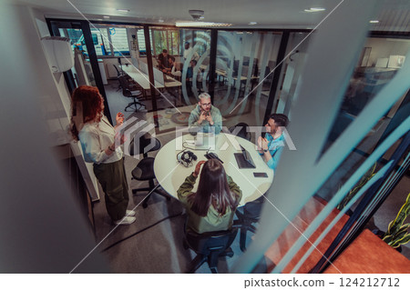 A group of young business entrepreneurs engages in a focused meeting, discussing various business strategies and collaboratively solving challenging problems, showcasing ambition, creativity, and 124212712