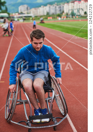 A person athlete with disability in a wheelchair racing on an outdoor track. 124212729