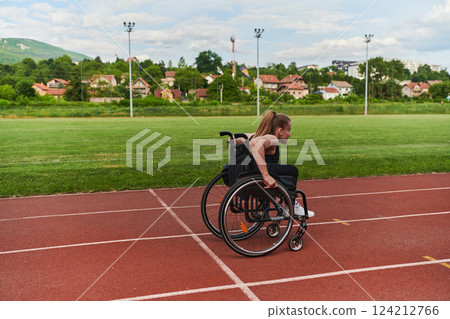 A woman with disablity driving a wheelchair on a track while preparing for the Paralympic Games A woman with disablity driving a wheelchair on a track while preparing for the Paralympic Games 124212766