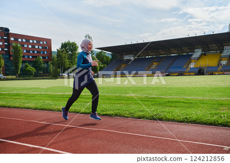 A muslim woman in a burqa sports muslim clothes running on a marathon course and preparing for upcoming competitions 124212856