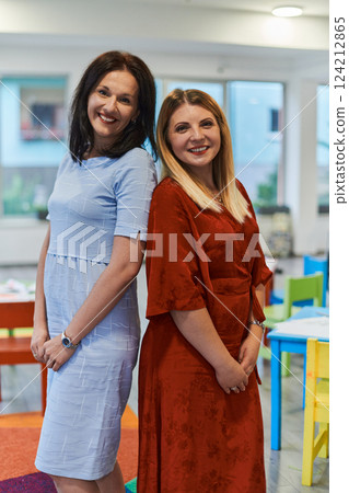 Portrait of a two teacher in a preschool institution, in the background of the classrooms Portrait of a two teacher in a preschool institution, in the background of the classrooms 124212865