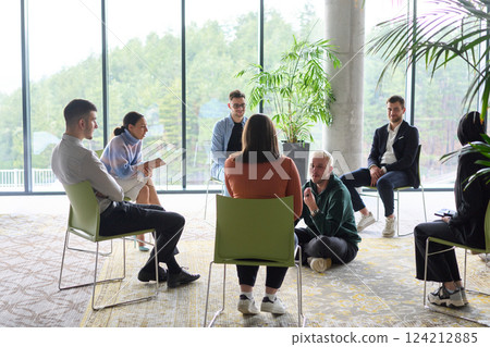 Corporate business team meeting with a manager or coach. Group of happy diverse, multiracial people sitting in a circle  124212885
