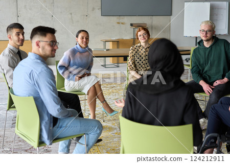 Corporate business team meeting with a manager or coach. Group of happy diverse, multiracial people sitting in a circle  124212911