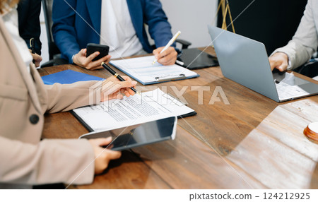 business people and lawyers discussing contract papers sitting at the table. Concepts of law, advice, legal services. 124212925