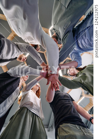 A group of young businessmen offer their hands together, symbolizing togetherness in the business world 124212975
