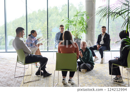 Corporate business team meeting with a manager or coach. Group of happy diverse, multiracial people sitting in a circle  124212994