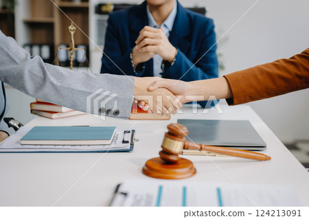 Judge and client shaking hands and lawyers discussing contract papers after adviced at courtroom, lawyer service concept Judge and client shaking hands and lawyers discussing contract papers after adviced at courtroom, lawyer service concept 124213091