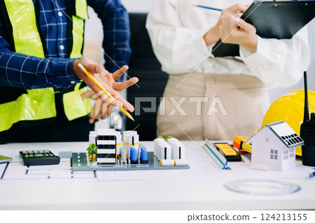 Creative architect projecting on the big drawings with architectural project at construction site at desk in office 124213155