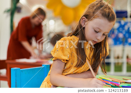 Creative kids sitting in a preschool institution, draw and have fun while they get an education 124213189