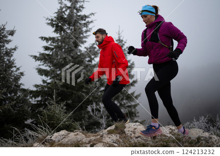 trail running couple man and woman running on a mountain path 124213232
