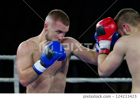 Fierce boxing match showcases athletes' power and skill. 124213423