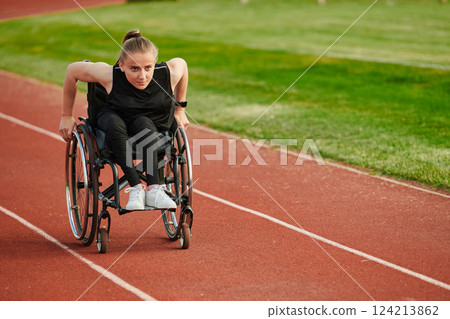 A woman with disablity driving a wheelchair on a track while preparing for the Paralympic Games 124213862
