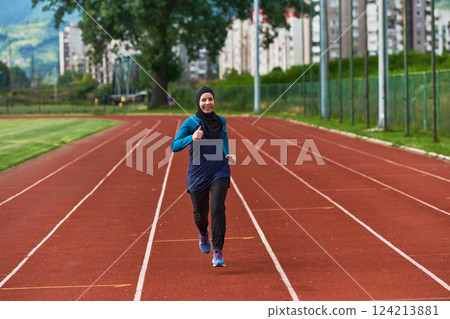 A muslim woman in a burqa sports muslim clothes running on a marathon course and preparing for upcoming competitions 124213881