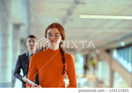 In the dynamic environment of a modern startup company, the director engages in a discussion with his young business colleague while they walk, reflecting the spirit of collaboration and innovation in 124213891
