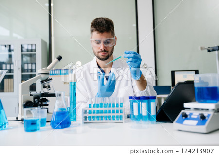 scientists conducting research investigations in a medical laboratory, a researcher in the foreground scientists conducting research investigations in a medical laboratory, a researcher in the foreground 124213907