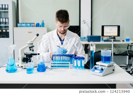scientists conducting research investigations in a medical laboratory, a researcher in the foreground 124213940