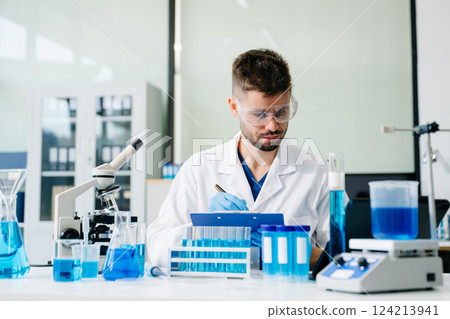 scientists conducting research investigations in a medical laboratory, a researcher in the foreground scientists conducting research investigations in a medical laboratory, a researcher in the foreground 124213941