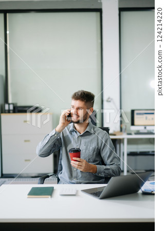 Confident businessman working on finance analysis with a tablet and laptop at office desk. professional workplace concepts. Confident businessman working on finance analysis with a tablet and laptop at office desk. professional workplace concepts. 124214220