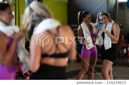 Two fitness women posing for a photoshoot after an intense workout, capturing their strength, determination, and fitness journey. Two fitness women posing for a photoshoot after an intense workout, capturing their strength, determination, and fitness journey. 124214623