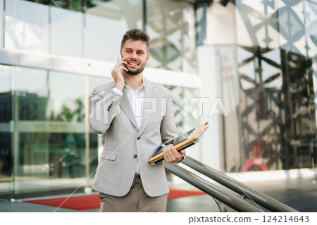 Modern businessman outdoors, using a tablet. Ideal for business, technology, and innovation themes. 124214643