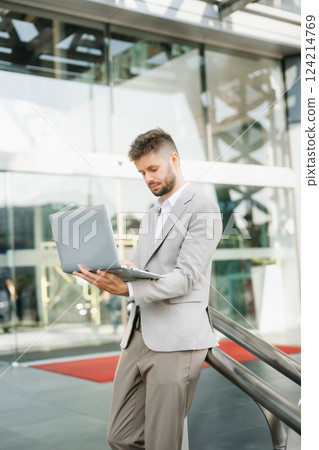 Modern businessman outdoors, using a tablet. Ideal for business, technology, and innovation themes. Modern businessman outdoors, using a tablet. Ideal for business, technology, and innovation themes. 124214769