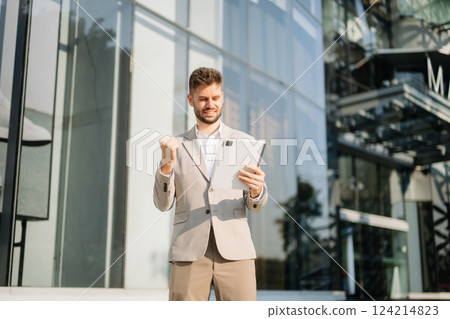 Modern businessman outdoors, using a tablet. Ideal for business, technology, and innovation themes. 124214823