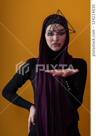 Elegant Muslim woman in a hijab with a geometric structure in a conceptual portrait. Elegant Muslim woman in a hijab with a geometric structure in a conceptual portrait. 124214830