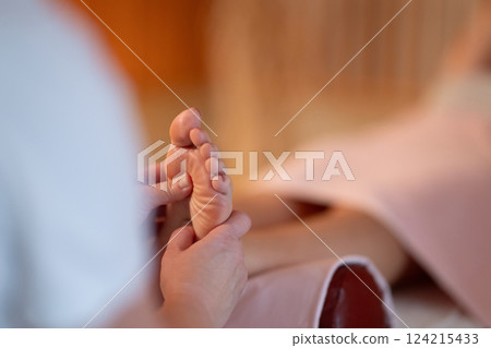 Foot Massage Therapy in a Relaxing Spa Setting. A professional massage therapist in a white uniform provides a soothing foot massage to a client in a calm and serene spa environment Foot Massage Therapy in a Relaxing Spa Setting. A professional massage therapist in a white uniform provides a soothing foot massage to a client in a calm and serene spa environment 124215433