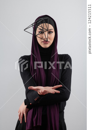 Elegant Muslim woman in a hijab with a geometric structure in a conceptual portrait. Elegant Muslim woman in a hijab with a geometric structure in a conceptual portrait. 124215511