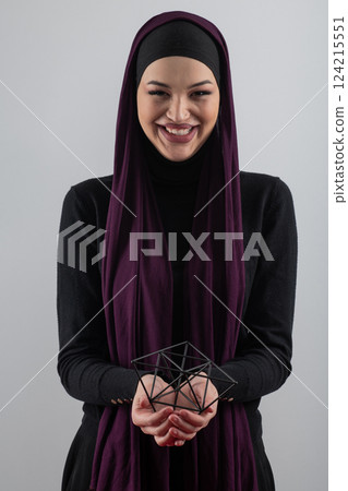 Elegant Muslim woman in a hijab with a geometric structure in a conceptual portrait. Elegant Muslim woman in a hijab with a geometric structure in a conceptual portrait. 124215551