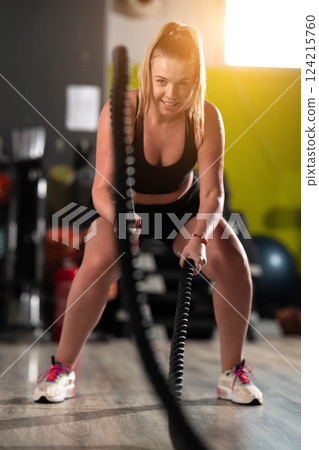 Fit Woman Performing Rope Conditioning Exercise in the Gym 124215760