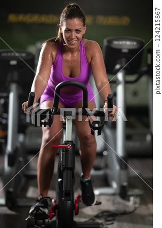A focused fitness woman performing a conditioning workout in the gym, pushing her limits with strength, determination, and intense dedication. A focused fitness woman performing a conditioning workout in the gym, pushing her limits with strength, determination, and intense dedication. 124215867