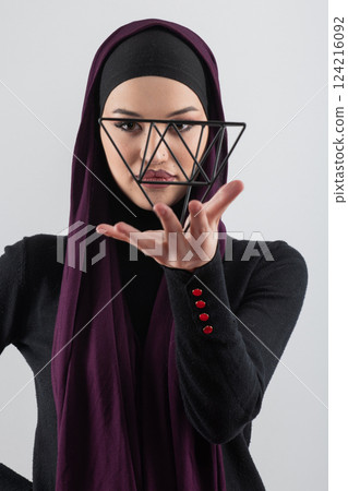 Elegant Muslim woman in a hijab with a geometric structure in a conceptual portrait. Elegant Muslim woman in a hijab with a geometric structure in a conceptual portrait. 124216092