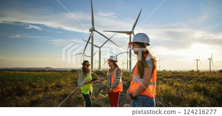 Female engineers using tablets to monitor and manage wind turbine operations on site.Generated image 124216277