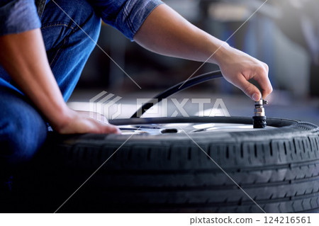 Air pressure, tire and mechanic working in garage with pump in hand. Man in auto service, vehicle care and checking car wheel in workshop. Technician doing maintenance check in motor repair industry Air pressure, tire and mechanic working in garage with pump in hand. Man in auto service, vehicle care and checking car wheel in workshop. Technician doing maintenance check in motor repair industry 124216561