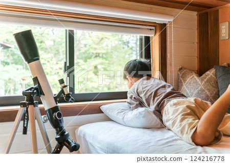 Children playing with a telescope during summer vacation (cottage, villa, mountain hut, camping, glamping) 124216778