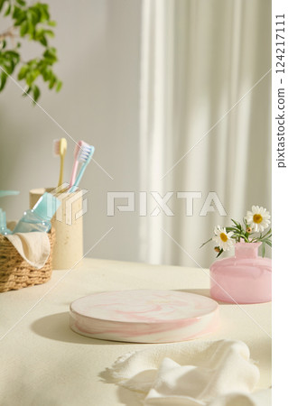 Gradient pink marble pedestal to place products. Vintage ink pink vase holds pretty flowers. Cup at the back holds toothbrushes, the wicker basket holds cosmetic jars of liquid solutions. Gradient pink marble pedestal to place products. Vintage ink pink vase holds pretty flowers. Cup at the back holds toothbrushes, the wicker basket holds cosmetic jars of liquid solutions. 124217111