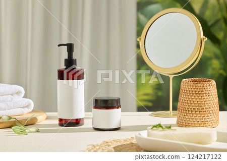 Tall plastic bottles and jars without labels, for design. Round table mirrors made of shiny gold metal. Brown rattan baskets, stacked towels placed on round wooden trays. Bottle mockup for cosmetics. 124217122