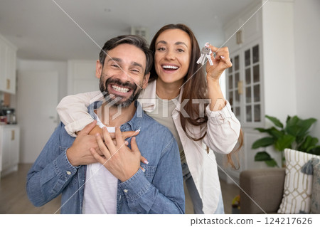 Excited Hispanic couple of new happy homeowners posing for portrait Excited Hispanic couple of new happy homeowners posing for portrait 124217626