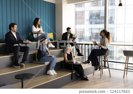 Diverse group of people listening attentively speech of young speaker Diverse group of people listening attentively speech of young speaker 124217683