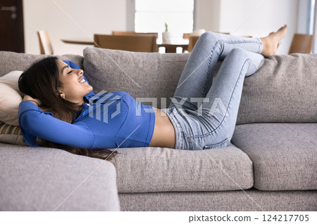 Woman spend time lying on comfortable sofa in living room 124217705