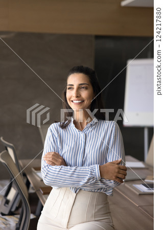 Beautiful competent businesslady posing alone in modern conference room 124217880