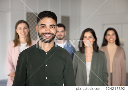 Arabian man posing confidently in foreground, exuding satisfaction and pride Arabian man posing confidently in foreground, exuding satisfaction and pride 124217892