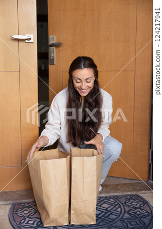 Happy young woman receiving order from online supermarket delivery service 124217941