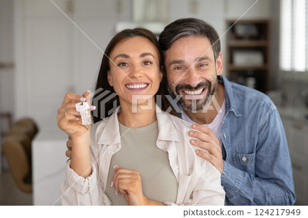 Happy Latin couple of homeowners showing key from new home 124217949