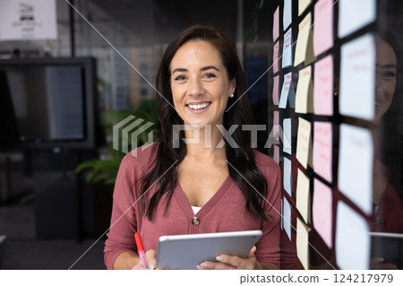 Happy business leader woman posing for portrait at glass board 124217979