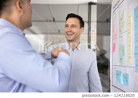 Happy successful Latin businessman giving fist bump gesture to colleague Happy successful Latin businessman giving fist bump gesture to colleague 124218020