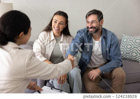 Positive couple of homeowners shaking hands with financial adviser Positive couple of homeowners shaking hands with financial adviser 124218029